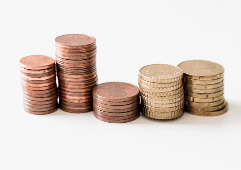 stacked round gold-colored coins on white surface