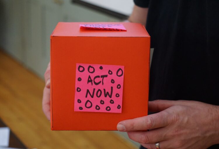 person holding red box